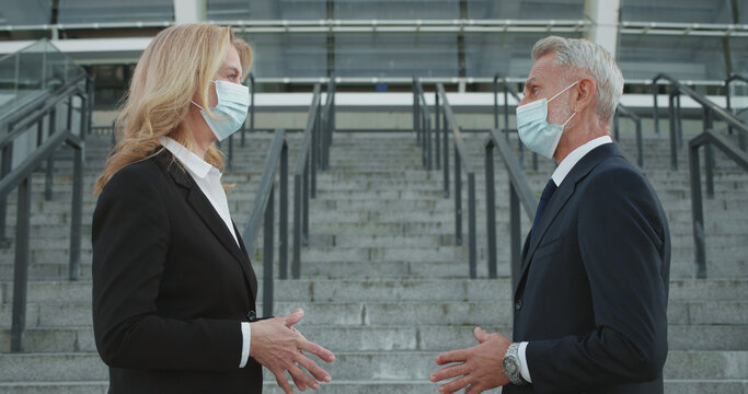 Business partners wearing protective medical masks at meeting, social distancing, pandemic safety