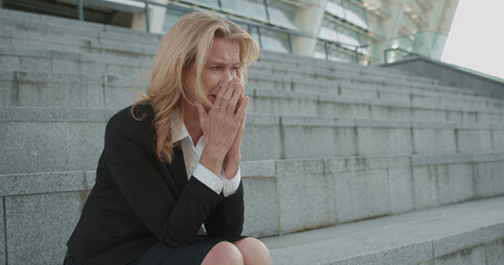 Upset businesswoman crying on stairs alone, depressed by failure at work, stress