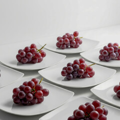 Arrangement of Red Seedless Grapes on a White Plate