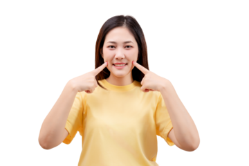 Asian young beautiful smiling in a yellow shirt and pointing to her cheeks with both index fingers.