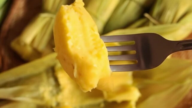 Video 4k of a fork picking up a piece of pamonha, a Brazilian dessert made from corn, typical of June festivals