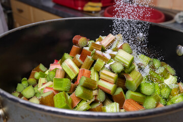 Sprinkling Sugar or Granulated Sweetener on Chopped Rhubarb in Pot