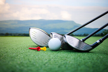 Golf Clubs and Ball on Green Turf with Scenic Background View
