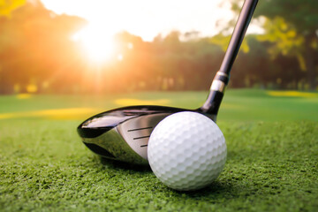 Golf Club and White Ball on Green Grass at Sunset in Nature