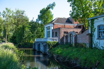Facade, creek and backyards of the Cortewalle castle domain in Beveren, East Flanders, Belgium