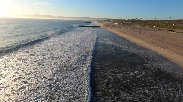 A dusk low angle aerial fast flyover of an empty Playa Del Rey Beach. Beaches were closed during the COVID-19 pandemic of 2020. Flown with FAA permission by a licensed pilot. Longer segments available