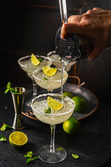 Margarita cocktail with lime and ice on dark wooden table with copy space. Classic Margarita and Daiquiri Cocktail.