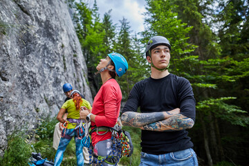 Climbers preparing for an ascent in a forested mountain area under a cloudy sky