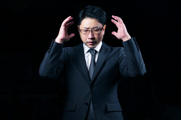 暗闇の中で悩んでいるビジネスマン