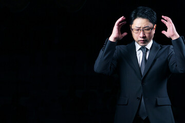 暗闇の中で悩んでいるビジネスマン