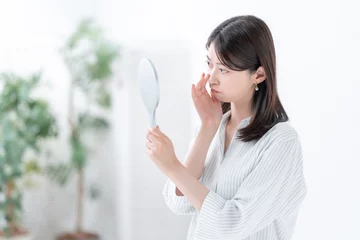 Fotobehang 手鏡を見て悩む女性 © naka