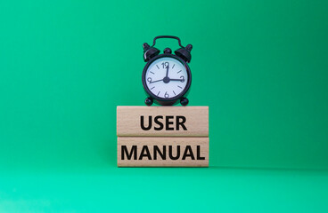 User Manual symbol. Concept words User Manual on wooden blocks. Beautiful green background with...