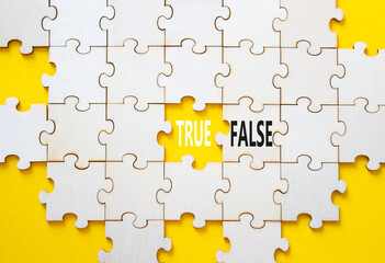 True or False symbol. Concept word True or False on wooden puzzle. Beautiful yellow background....