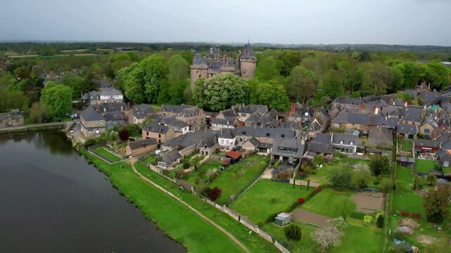4K cinematic drone view of Chateau de Combourg and the lake. Historic medieval fortress, traditional village and scenic river valley in Brittany near Saint-Malo, France