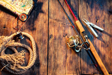 Fishing screensaver. Rod and fishing gear. Hobbies and recreation. Active recreation. Items for fishing. Wooden background.