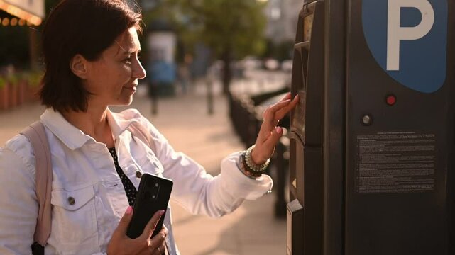Girl Paying For Car Parking On A City Street Parking Meter Machine