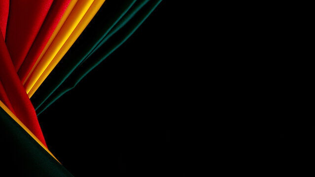 Black History Month, Juneteenth background. Red, yellow, green colors silk flag on flat black satin background