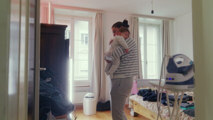 Mother standing in the bedroom gently tapping baby&rsquo;s back after breastfeeding, comforting and nurturing, intimate caregiving moment in a peaceful home setting