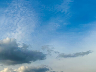 Stormy sky with dark, snowy clouds on a spring day. Clouds are floating across the sky. Dramatic clouds. Dark blue clouds swiftly floating across blue sky. Sky texture, abstract nature background.