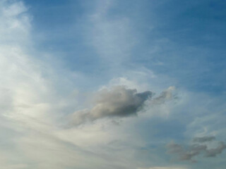 Stormy sky with dark, snowy clouds on a spring day. Clouds are floating across the sky. Dramatic clouds. Dark blue clouds swiftly floating across blue sky. Sky texture, abstract nature background.