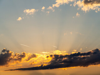 sunset sky with clouds and sunbeams
