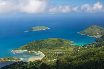 The view on the coastline with beaches and green hills, islands and blue Indian Ocean from the top of the mountain Morne. Mahe, the Seychelles