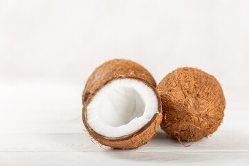 Set of fresh whole and half coconuts and slices on wooden background. Coconut flakes. Vegan. Tropical nut, fruit. Place for text. Copy space.