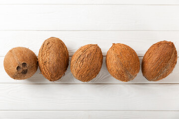 Set of fresh whole and half coconuts and slices on wooden background. Coconut flakes. Vegan....