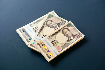 黒いテーブルに置かれた一万円札の札束