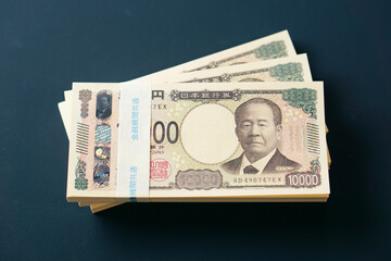 黒いテーブルに置かれた一万円札の札束