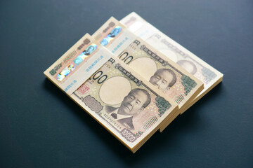 黒いテーブルに置かれた一万円札の札束