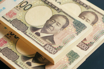 黒いテーブルに置かれた一万円札の札束