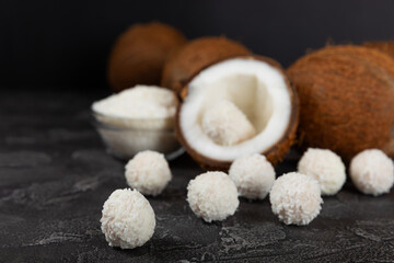 Coconut candies on a wooden background. Candies with chocolate, almonds and delicate butter cream. Coconut flakes. tasty sweets.Tasty ball-shaped chocolate candies.Dessert. Space for text.copy space