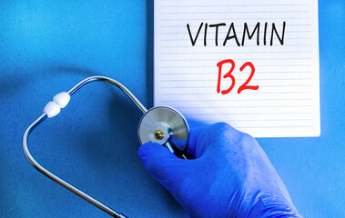 Vitamin B2 riboflavin symbol. Concept words Vitamin B2 on beautiful white note. Doctor's hand in...