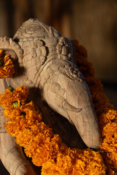 Wooden sculpture of a traditional Hindu elephant wearing a wreath of marigolds in Bali, Indonesia. 