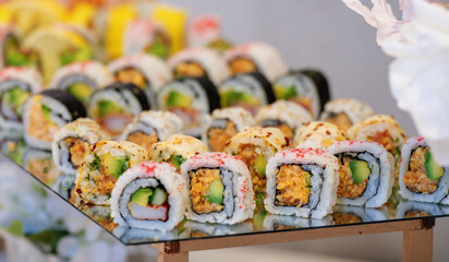 close up view of a plate filled with sliced sushis on a table at a buffet