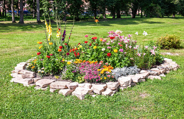 Flower bed in a city park with various plants and flowers