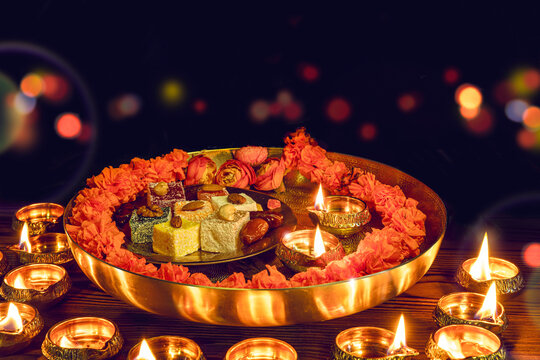 Tray with Diwali treats. Diwali lamp diya or Deepavali or Deepawali. Hindu festival of lights. Celebrating in Indian religions Jainism and Sikhism. Offering to the gods, a spiritual rite.