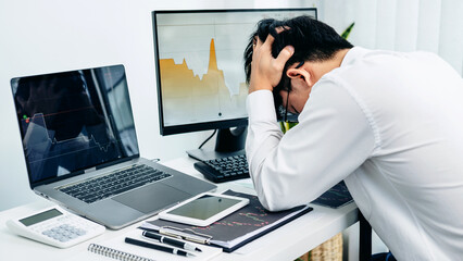 Fototapeta premium Businessman is looking information stock data chart in stock market on laptop screen and having stress from falling