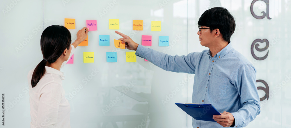 Poster two business executive team holding and taking notes keyword on board wall to brainstorm about a new