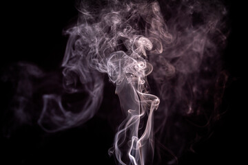Soft smoke curls gracefully against a dark background, creating ethereal patterns in the air during...