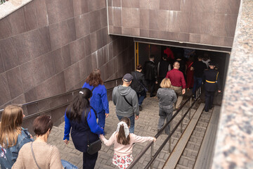 A crowd of people descend into an underground passage to cross the road