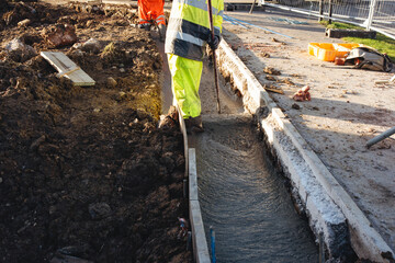Skilled workers pouring and leveling concrete on a construction site