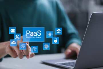 PaaS, Platform as a Service concept. Cloud computing service on software platform. Businessman using laptop with PaaS icon on virtual screen.