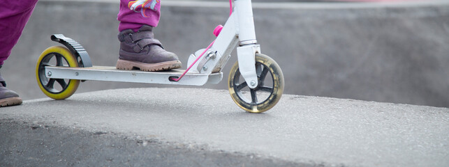Skate park. Teenagers ride scooters in a skate park.