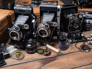 Collection of old cameras, on wooden background.