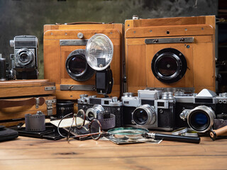 Old cameras in a composition on a wooden background