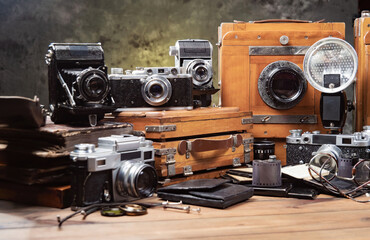 Old cameras in a composition on a wooden background