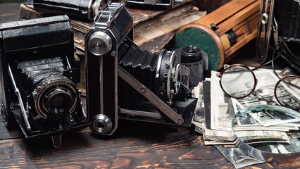 Collection of old cameras, on wooden background.