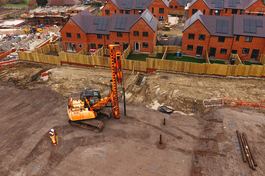 Aerial view from drone at Heavy machinery piling rig busy drilling at construction site for new homes